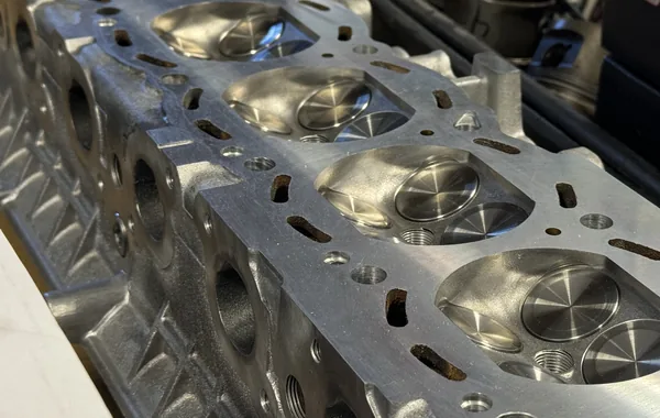 Close-up of machined combustion chambers and valve seats on a cylinder head