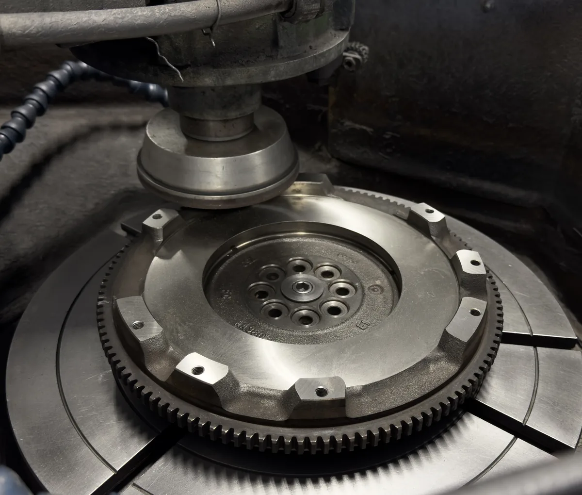 A flywheel clamped on the rotary chuck of a Winona FG-5000 grinder at RVJ Machine in Auburn, California