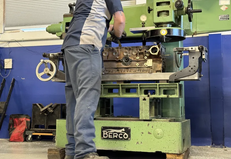 A machinist resurfacing a cast iron cylinder head on the Berco surface grinder at RVJ Machine