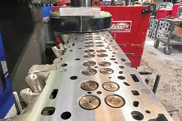 Cylinder head being resurfaced in a machine at RVJ Machine shop